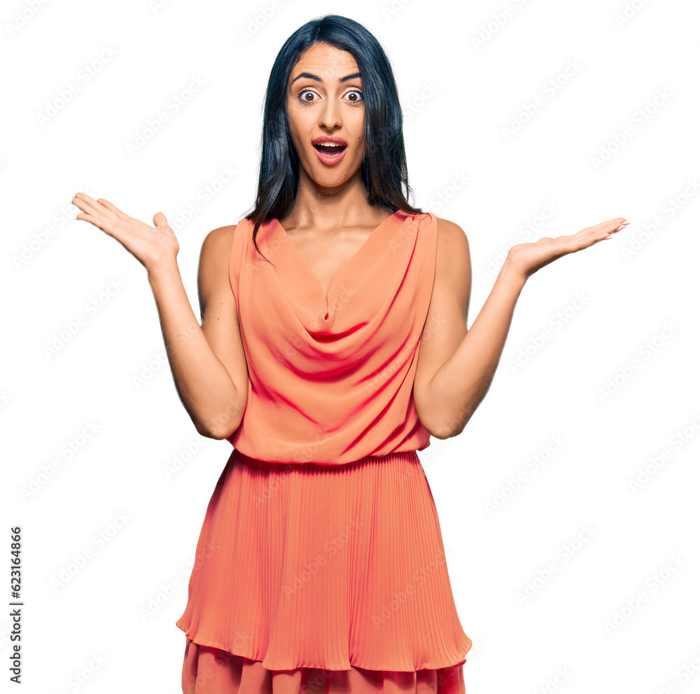 Beautiful hispanic woman wearing summer dress celebrating victory with happy smile and winner expression with raised hands Beautiful hispanic woman wearing summer dress celebrating victory with happy smile and winner expression with raised hands