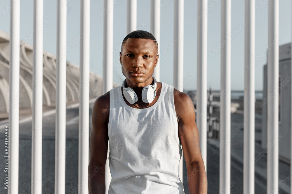 Confident black man standing near fence after training Confident black man standing near fence after training