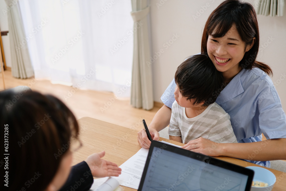 契約書にサインするクライアントと書き方の説明をする保険外交員 契約書にサインするクライアントと書き方の説明をする保険外交員