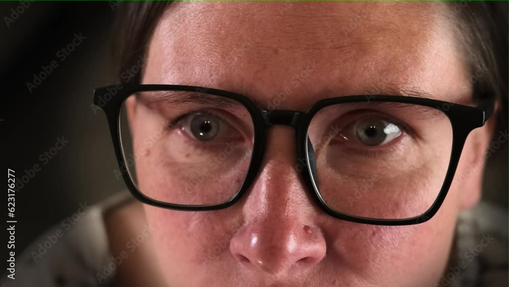 Close-up of an eye in glasses the face of a caucasian woman closely following the image with a surprised expression, vignette. Close-up of an eye in glasses the face of a caucasian woman closely following the image with a surprised expression, vignette.