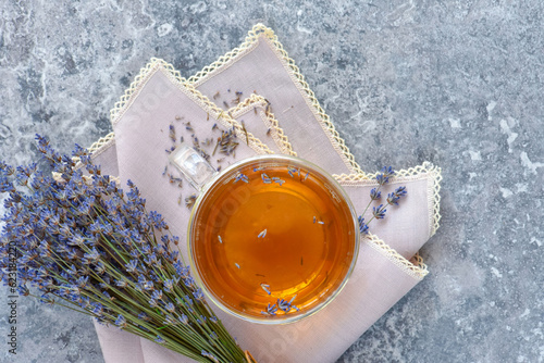 Fresh delicious tea with lavender and bunch of lavender flowers on gray stone table. Top view. Flat lay.