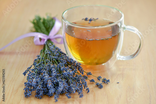 Cup of tea and lavender flowers on a wooden table