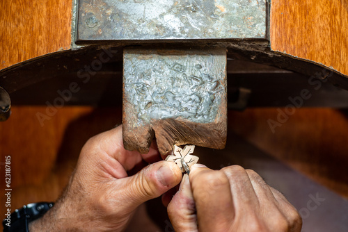 Foto Goldsmith jeweler man working in his crafting jewelry workshop creating and repairing a white gold or silver jewel with a burin in his work studio