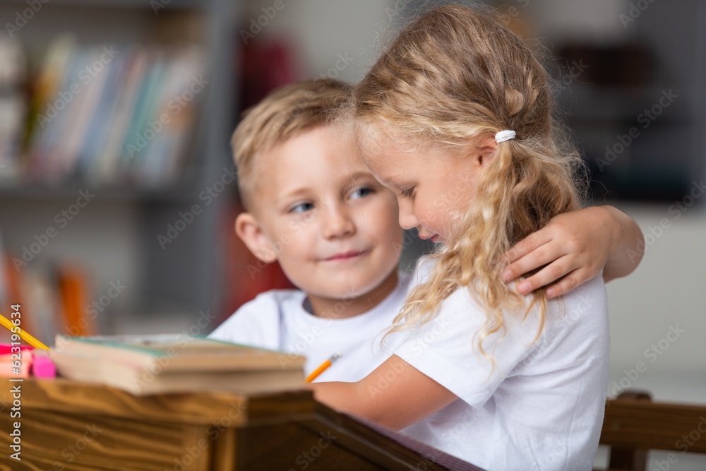Children reading books sitting for table Children reading books sitting for table