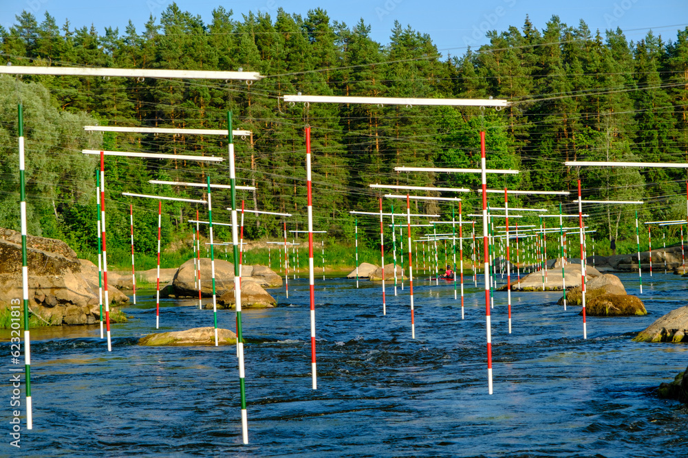 Fototapeta premium Canoe slalom course gate with paddler background. River Gauja Latvia. City Valmiera