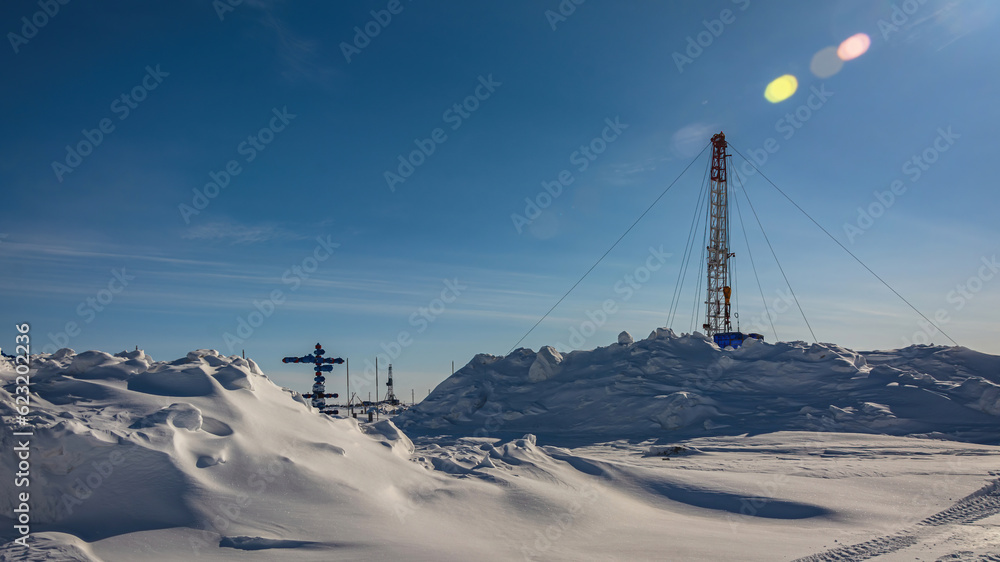The Northern gas field. There is a lot of snow in the foreground. In the background is a mobile installation for well repair. A frosty winter day. Sunny blue sky The Northern gas field. There is a lot of snow in the foreground. In the background is a mobile installation for well repair. A frosty winter day. Sunny blue sky