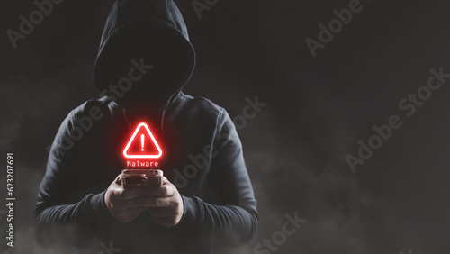 Hacker wear hood holding smartphone with red warning icon to launch ransomware malware attack on victim. Cyber security protection and hacking concept.
