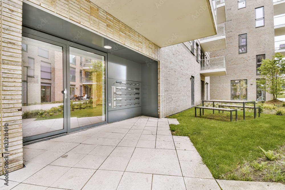 an outside area with some tables and benches on the grass in front of a building that is made of brick an outside area with some tables and benches on the grass in front of a building that is made of brick