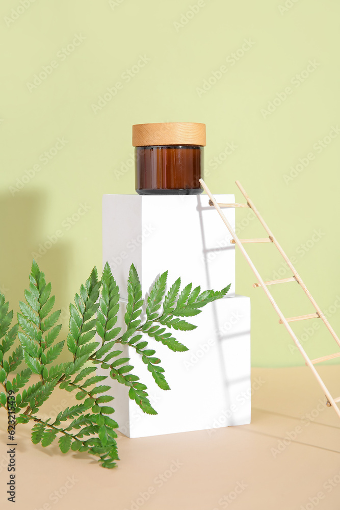 Composition with plaster podiums, jar of cosmetic product, fern leaf and decorative ladder on color background Composition with plaster podiums, jar of cosmetic product, fern leaf and decorative ladder on color background