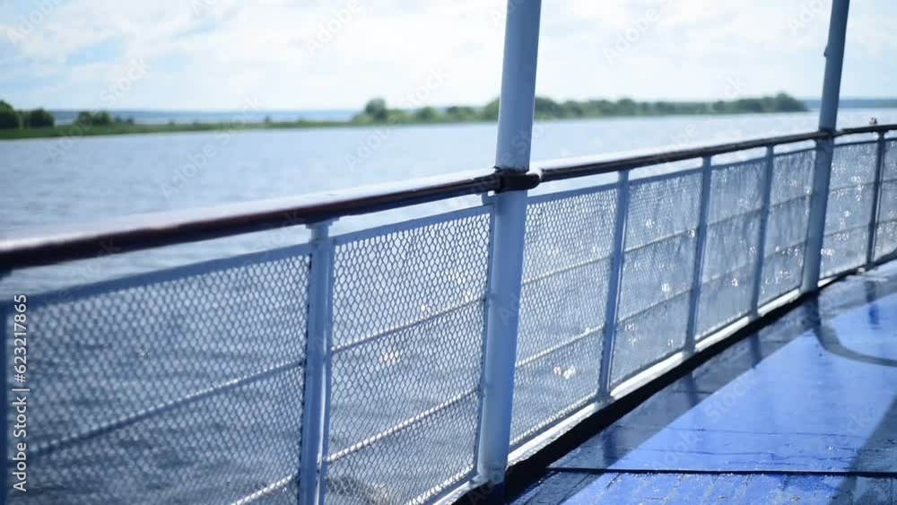 View from the deck of a motor ship floating along the river to the water shining from the sun and the green wooded shore. View from the deck of a motor ship floating along the river to the water shining from the sun and the green wooded shore.