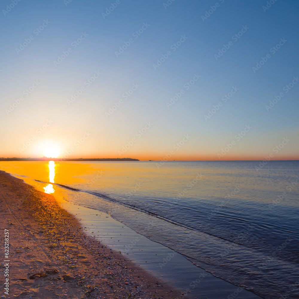 calm sea bay with sandy beach at the sunrise