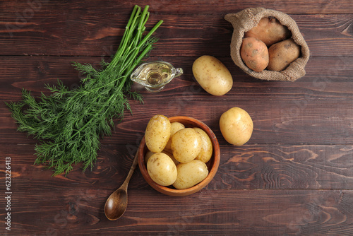 Bowl with sack bag of raw potatoes on wooden background