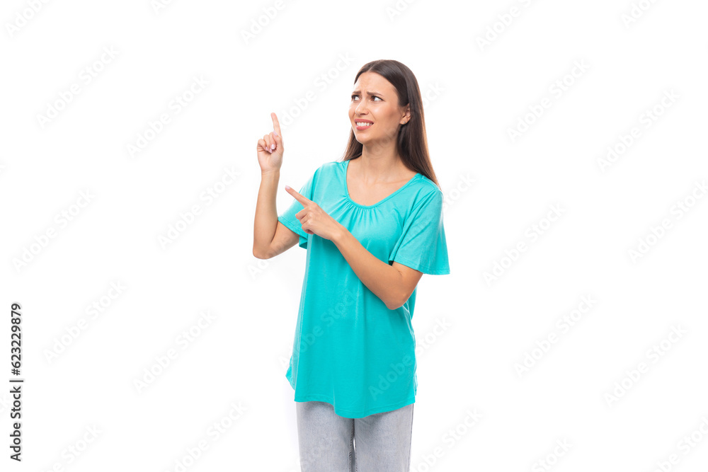 young pretty european woman with dark long hair dressed in a blue t-shirt points with her hands to the free space to insert advertising and text young pretty european woman with dark long hair dressed in a blue t-shirt points with her hands to the free space to insert advertising and text