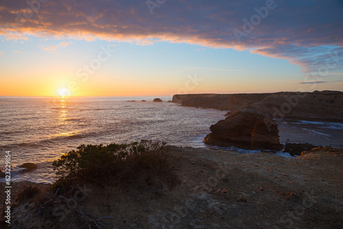 dreamy sunset scenery at Algarve coast, with colorful clouds and sinking sun