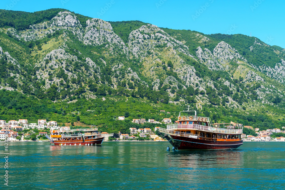 bay of Kotor with cruise ships and yachts for sea trips, Montenegro, bright sunny day, mountains and small towns on the coast, summer travel concept