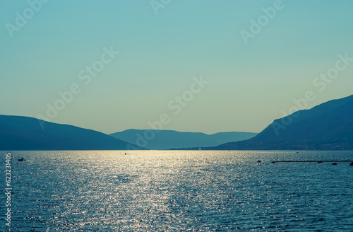 Fototapeta Naklejka Na Ścianę i Meble -  seascapes, a view of the Bay of Kotor during a cruise on a ship in Montenegro, a bright sunny day, mountains and small towns on the coast, the concept of a summer trip
