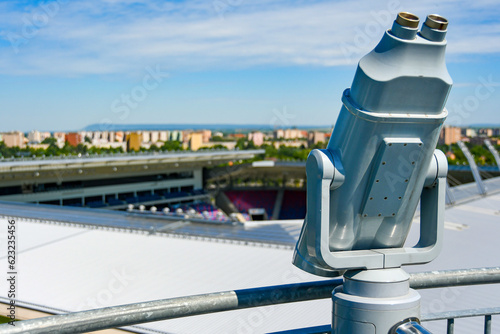 Billede på lærred Observation deck with telescope in the background, stadium and cityscape