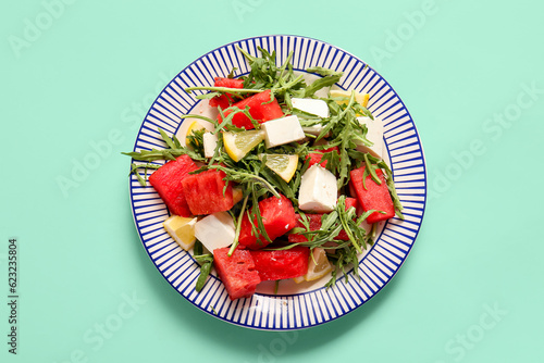 Plates of tasty watermelon salad on turquoise background photo