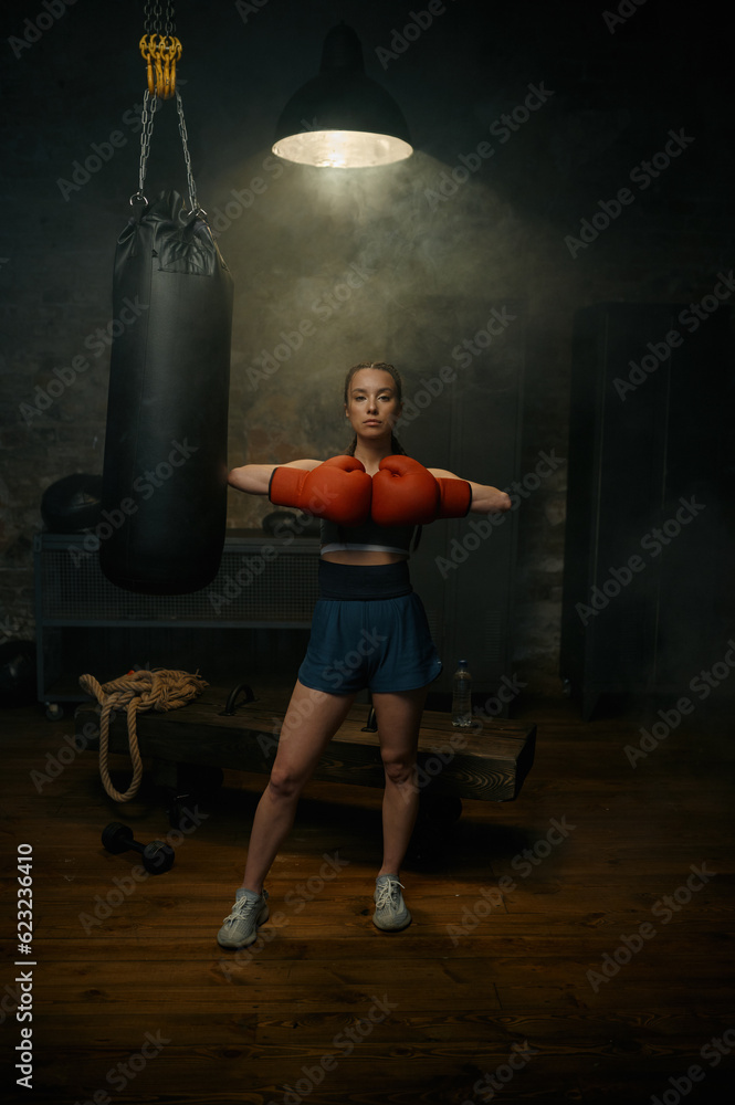 Portrait of professional beautiful sportive woman posing in red gloves