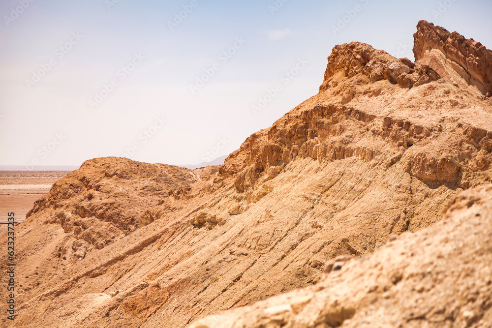 Landscape photography of Sahara desert hills with sand dunes, rock stones and blue sky, close up. View of expanses of sandy desert summer sunny day, Tozeur, Tunisia, Africa. Copy ad text space