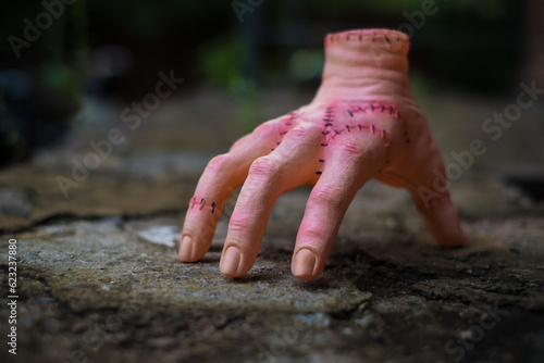 Scary realistic human hand with scars and stiches. Cut off hand with active fingers. Plastic toy. photo