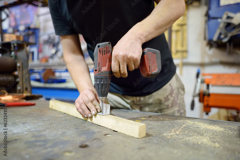 Metalwork craftsman working with metal at workshop. Man using drill. Diy. Small local business. Metalwork craftsman working with metal at workshop. Man using drill. Diy. Small local business.