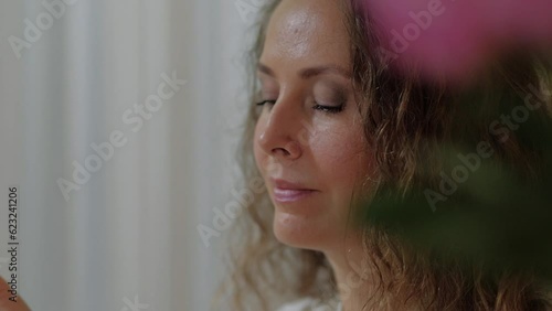 An attractive perfumer girl sniffs a jar of aroma oil and chooses a fragrance for herself. The concept of creating your own natural fragrance