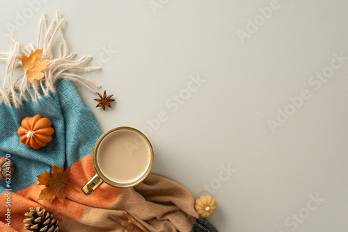 Fototapeta Naklejka Na Ścianę i Meble -  Coziness of being at home in autumn. Above view photo of a cup of hot coffee, patchy blanket, pumpkin-shaped candles, maple foliage and aromatic spices on grey isolated background with copy-space