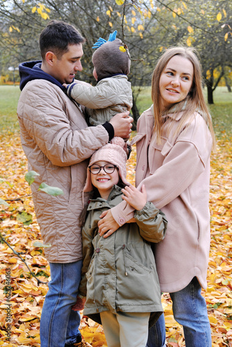 A family of four has fun in the autumn park