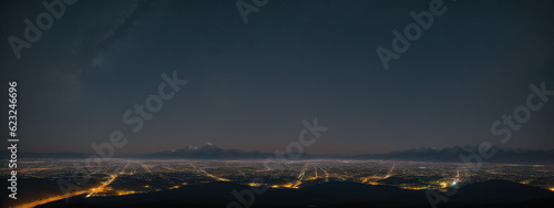 Nocturnal Tapestry: Mountainous Backdrop Illuminated by the Vibrant Cityscape