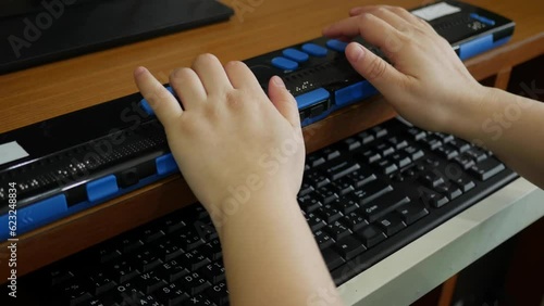 Close-up hands of person with blindness disability using computer keyboard and braille display or braille terminal a technology assistive device for persons with visual impairment