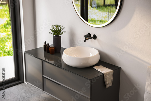 Chic bathroom setup with soap dispensers, towels, plant, black-framed mirror