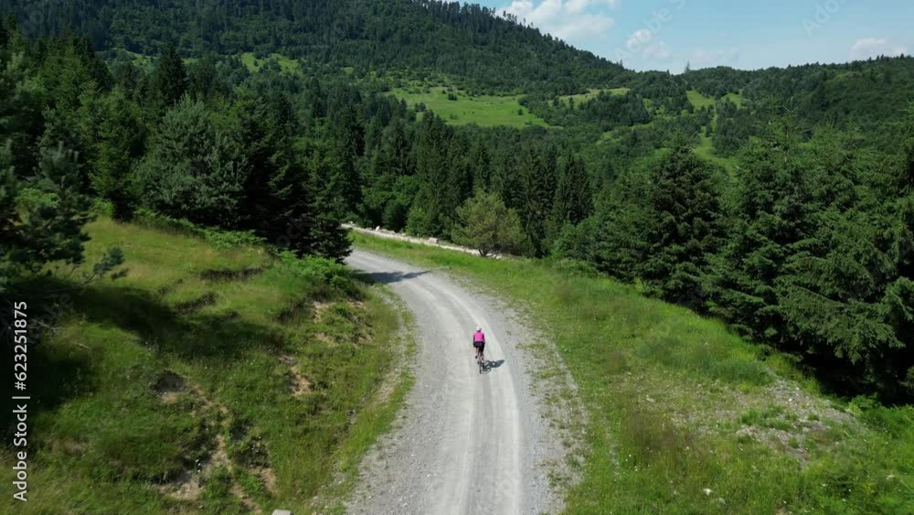Girl cyclist riding on gravel road. Cycling on gravel bicycle.Woman sport and travel.Outdoor adventures. Girl cyclist riding on gravel road. Cycling on gravel bicycle.Woman sport and travel.Outdoor adventures.