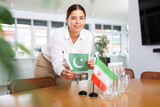 Secretary shows the flags of Pakistan and Iran on the table. Preparing for a meeting, negotiations.