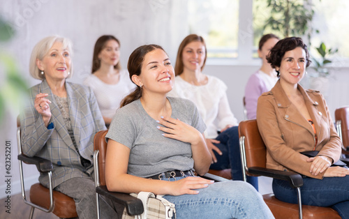 small group of women are sitting in audience and listening to lecture.Students laugh at amusing case from professor s practice photo