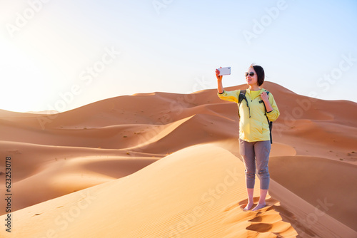 砂漠で撮影をする女性