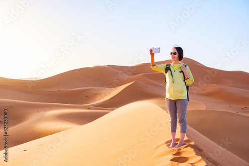 砂漠で撮影をする女性