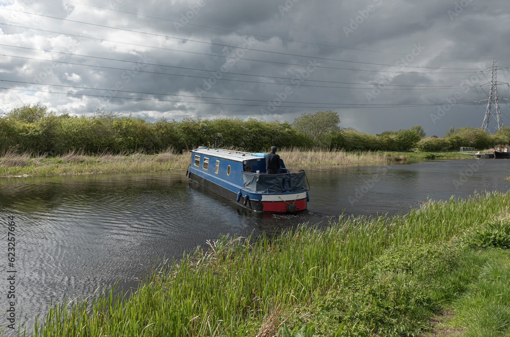 Long house boat turning around on a canal Long house boat turning around on a canal