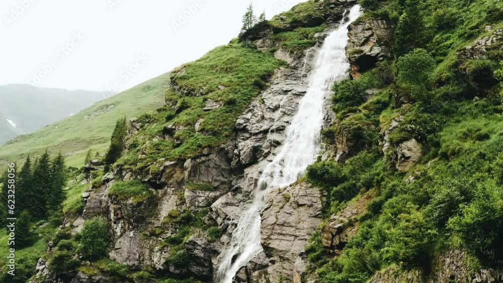 Powerful waterfall with water flowing off a cliff in nature. Clean river water in mountains Powerful waterfall with water flowing off a cliff in nature. Clean river water in mountains