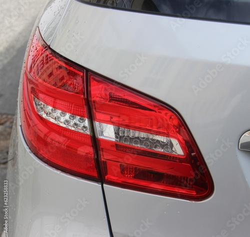 Closeup of crossover silver vehicle in Europe. Van background image. LED crossover vehicle tail light closeup. 
