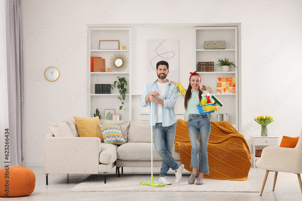 Spring cleaning. Couple with detergents and mop in living room