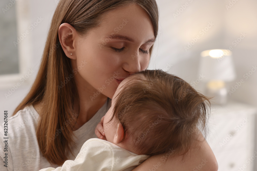 Happy mother kissing her little baby at home, closeup Happy mother kissing her little baby at home, closeup