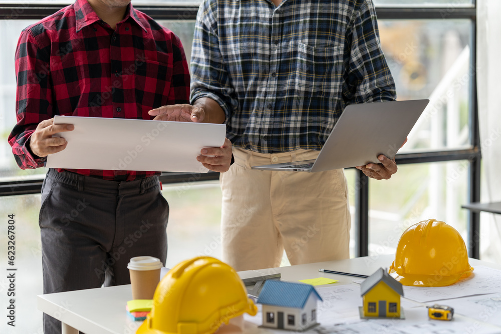 Engineer and contractor planning projects together at desk with blueprints. Engineer and contractor planning projects together at desk with blueprints.