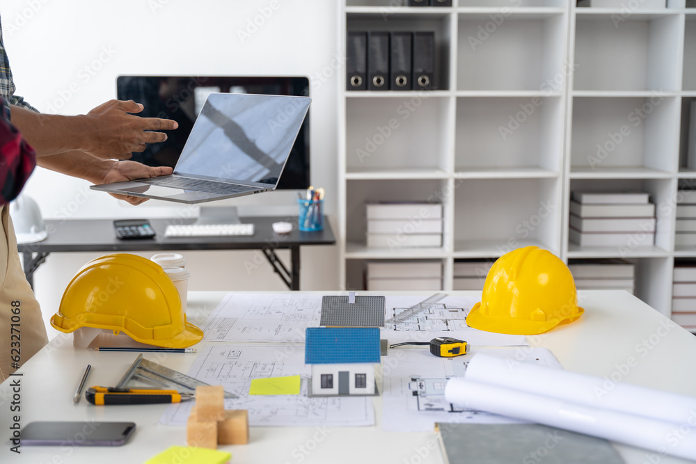 Engineer and contractor planning projects together at desk with blueprints. Engineer and contractor planning projects together at desk with blueprints.