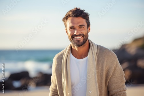Portrait of a smiling man standing on the beach at the day time