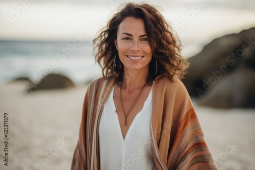 Portrait of a beautiful woman wrapped in a blanket on the beach