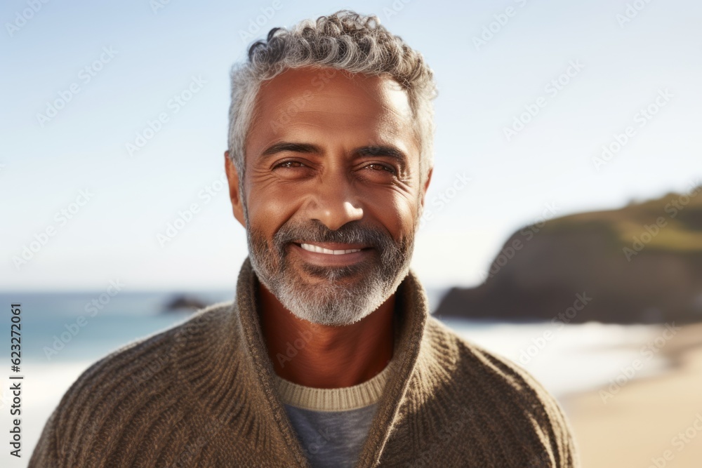 Portrait of smiling mature man standing on beach, looking at camera. Portrait of smiling mature man standing on beach, looking at camera.