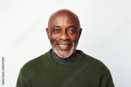 Portrait of a smiling senior man in a green sweater against white background © Anne Schaum
