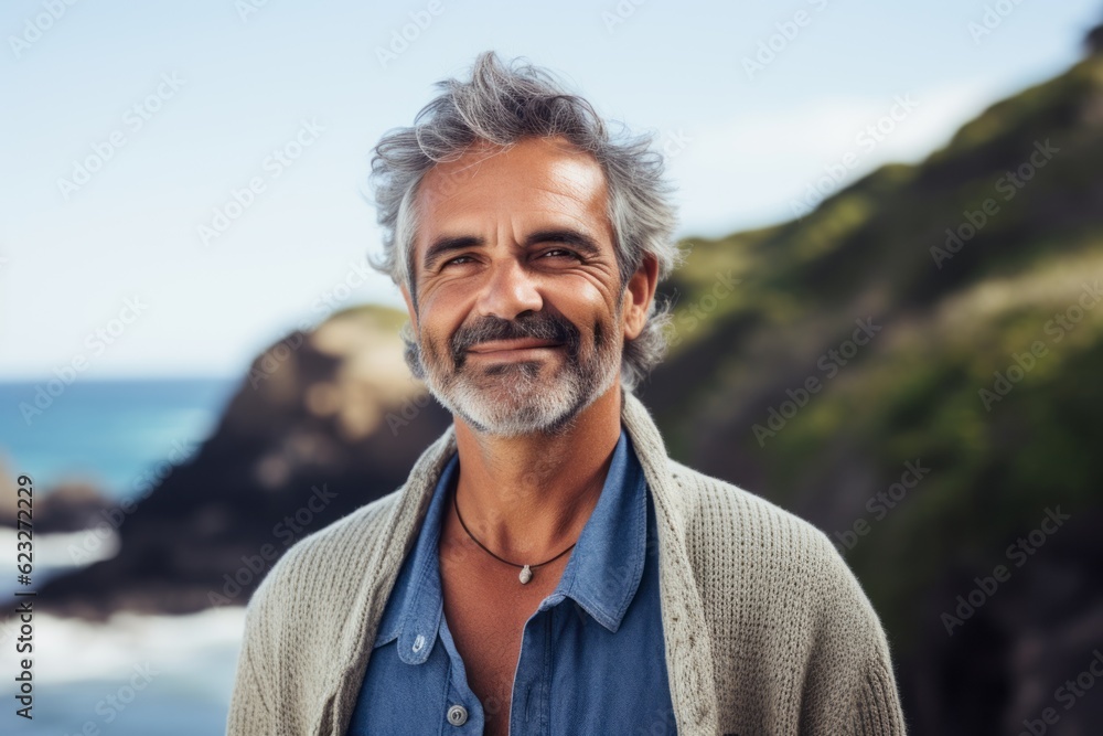 Portrait of smiling mature man standing by the ocean on a sunny day Portrait of smiling mature man standing by the ocean on a sunny day