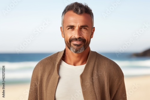 Handsome middle-aged man in a sweater on the beach